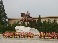 Blumenkörbe vor Kim Il Sung Statue im Mansudae-Künstlerstudio 